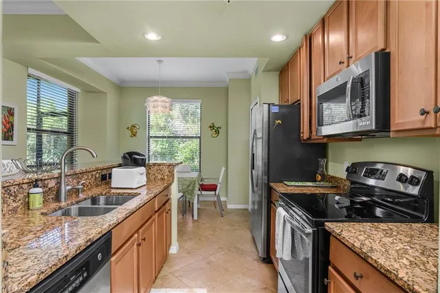 a kitchen with stainless steel appliances granite countertop a sink stove and refrigerator