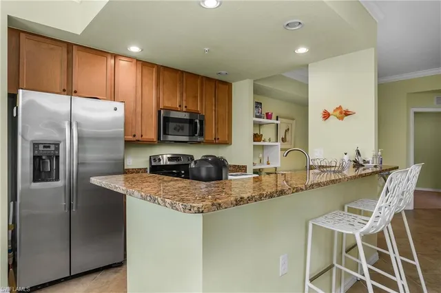 a kitchen with stainless steel appliances granite countertop a sink refrigerator and microwave