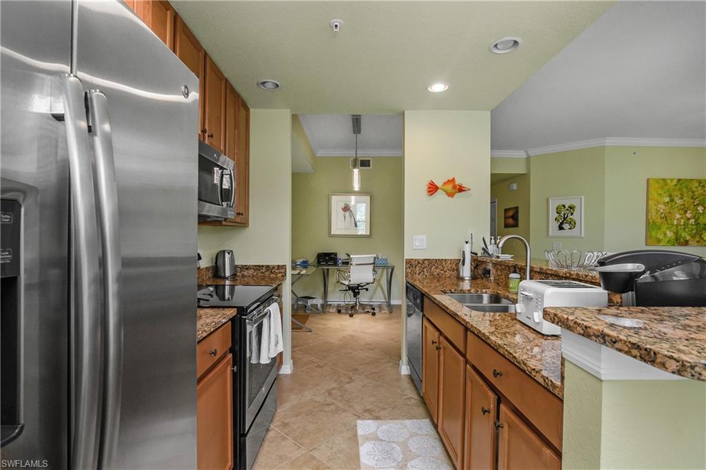 9832 Venezia Circle, Unit 1013 Naples, FL 34113 - Photo 16 of 34 a kitchen with counter top space and stainless steel appliances
