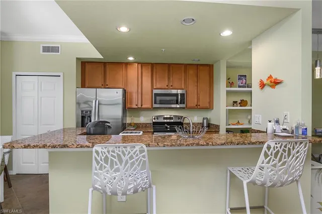 a kitchen with stainless steel appliances granite countertop a sink refrigerator and microwave