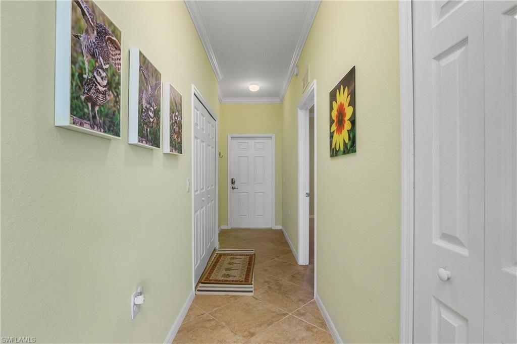 9832 Venezia Circle, Unit 1013 Naples, FL 34113 - Photo 20 of 34 a view of a hallway with wooden floor