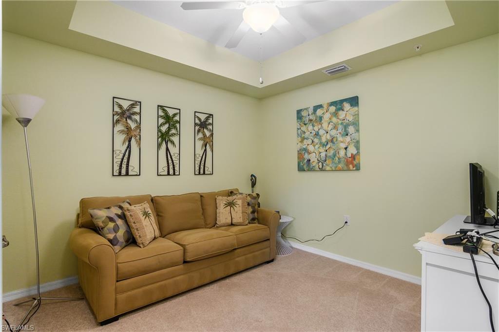 9832 Venezia Circle, Unit 1013 Naples, FL 34113 - Photo 21 of 34 a living room with furniture and a flat screen tv