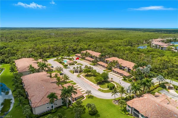 an aerial view of ocean and residential houses with outdoor space