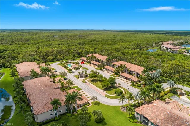 an aerial view of ocean and residential houses with outdoor space