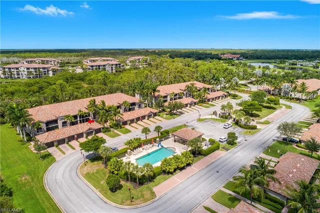 an aerial view of residential houses with outdoor space and trees