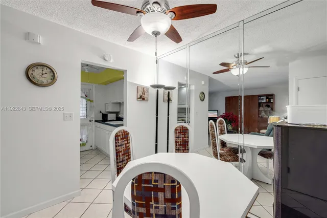 a very nice looking open kitchen with stainless steel appliances granite countertop a stove a refrigerator and a chandelier
