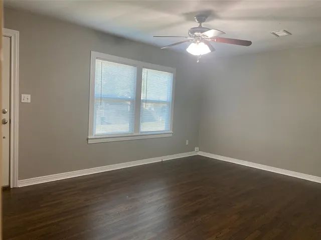 a view of wooden floor and a chandelier fan in a room