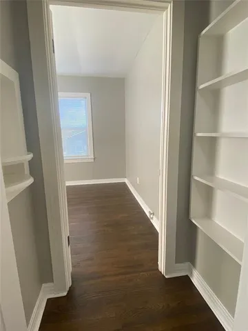 a view of a hallway with wooden floor and closet