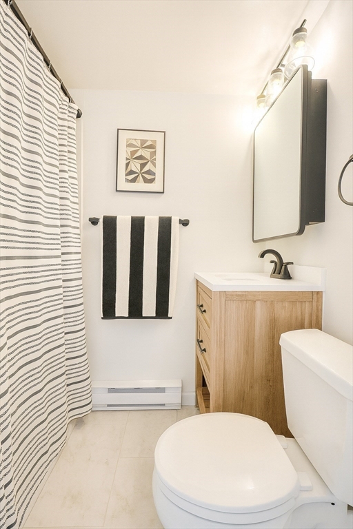 12 Stoneholm Street, Unit 529 Boston, MA 02115 - Photo 6 of 11 a white toilet sitting next to a bathroom sink and a mirror