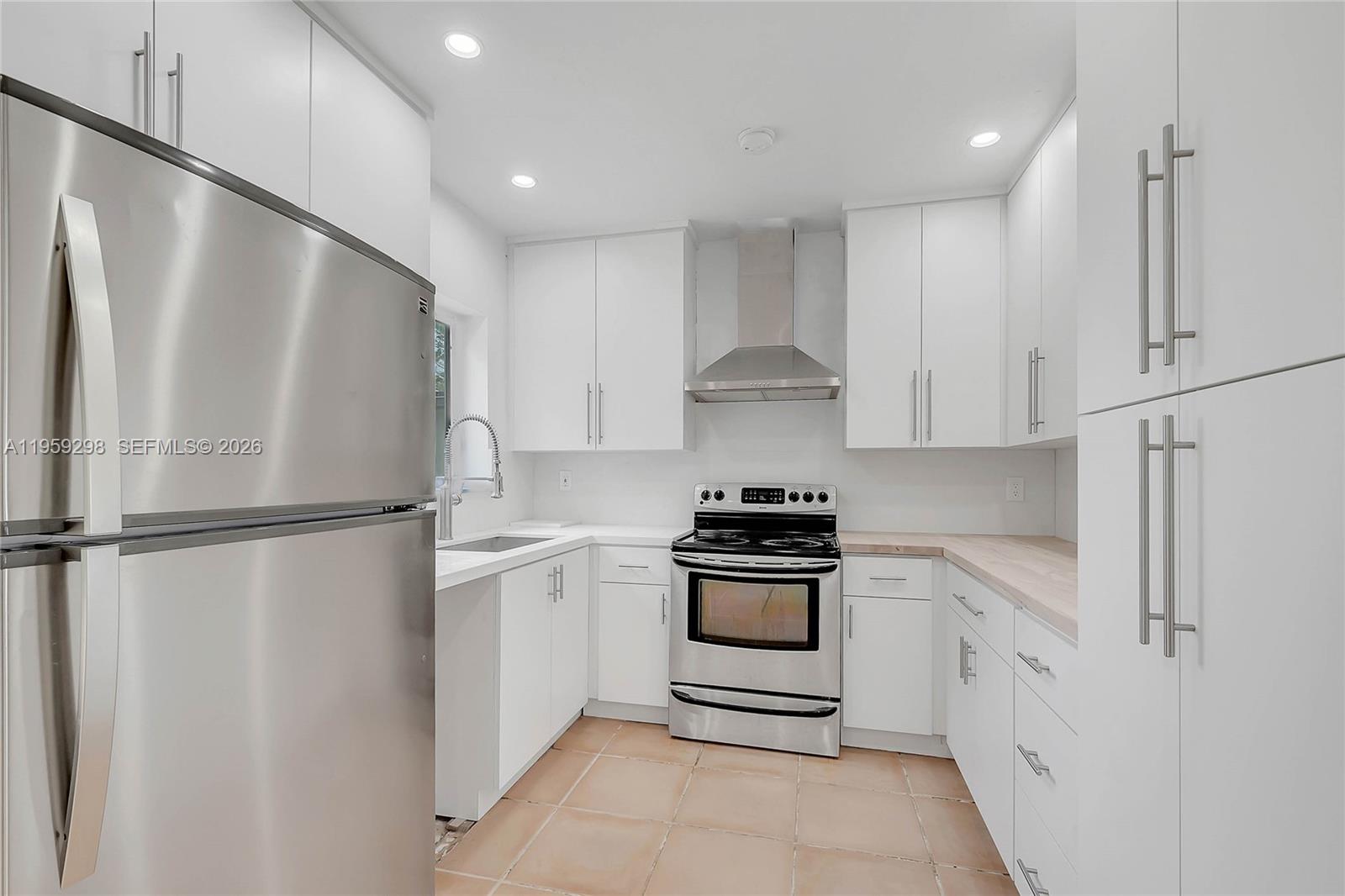 3050 Southwest 23rd Terrace Miami, FL 33145 - Photo 9 of 22 a kitchen with stainless steel appliances a refrigerator sink and stove