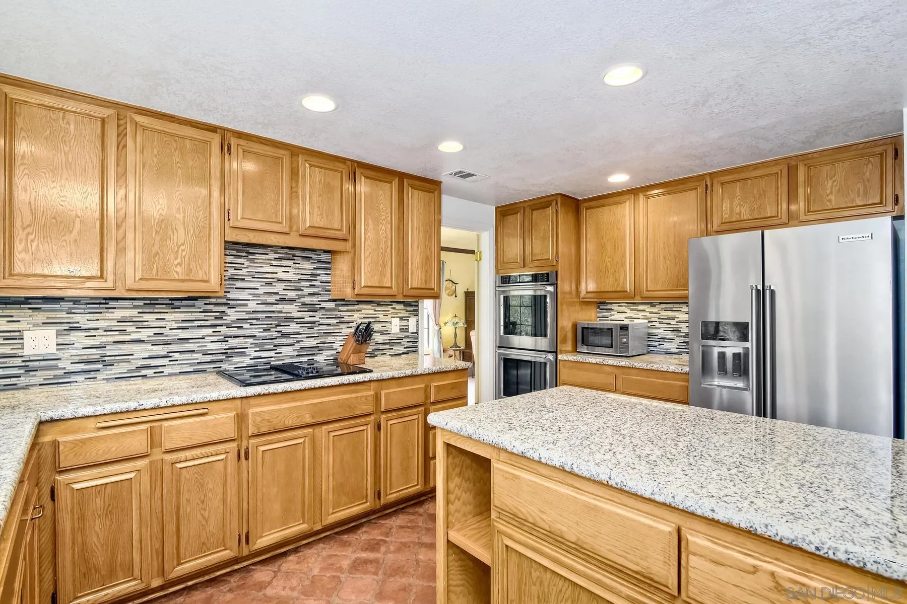 14859 Derringer Road Poway, CA 92064 - Photo 17 of 39 a kitchen with white cabinets and stainless steel appliances