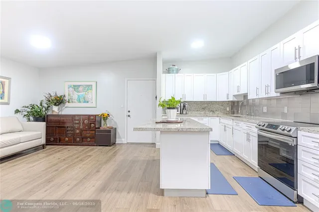 a kitchen with stainless steel appliances granite countertop a stove a sink and a white cabinets
