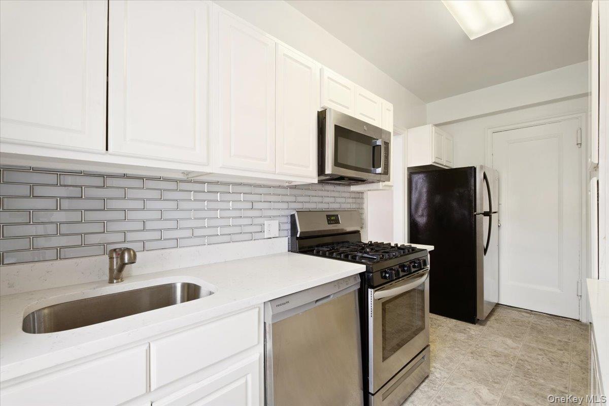 45 Popham Road, Unit 4J Scarsdale, NY 10583 - Photo 11 of 28 a kitchen with a sink stove and refrigerator