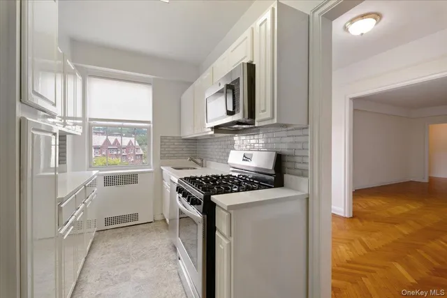a kitchen with white cabinets and appliances