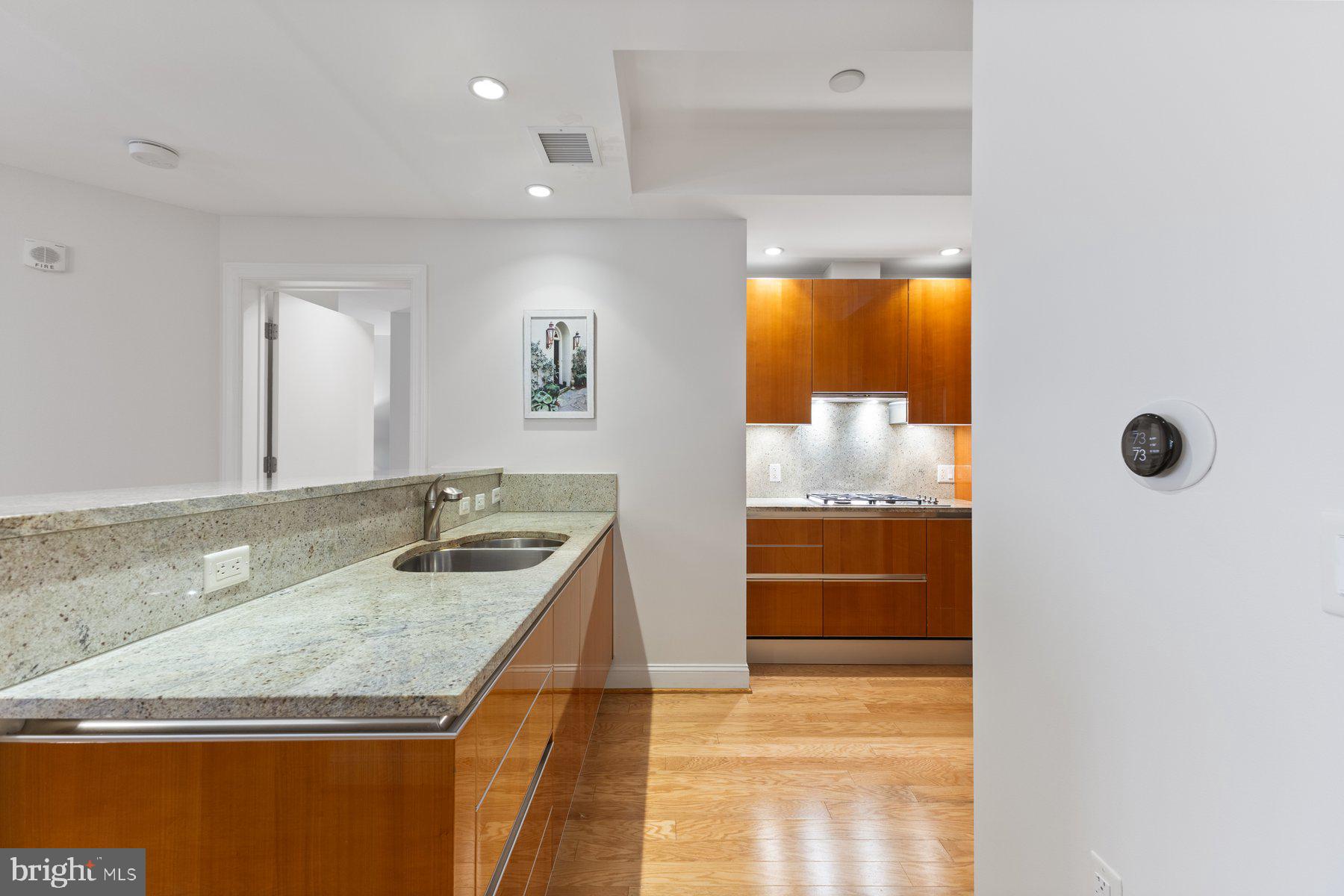 1881 North Nash Street, Unit 408 Arlington, VA 22209 - Photo 16 of 44 a bathroom with a granite countertop sink and mirror