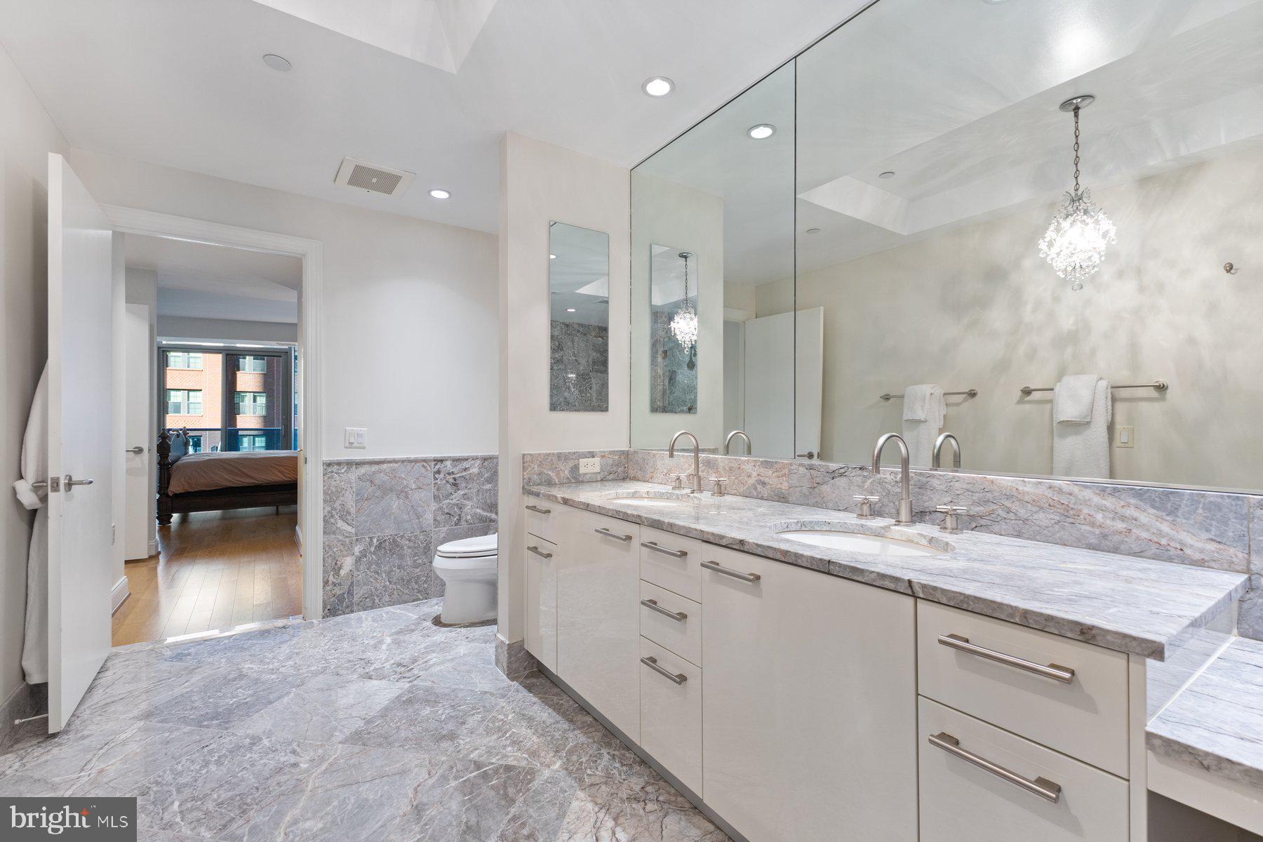 1881 North Nash Street, Unit 408 Arlington, VA 22209 - Photo 22 of 44 a bathroom with a granite countertop sink mirror and double