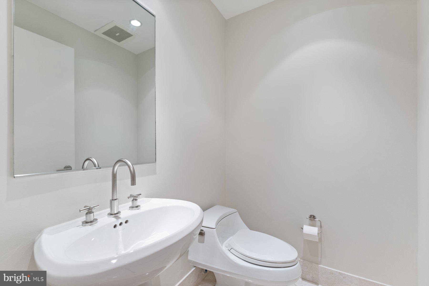 1881 North Nash Street, Unit 408 Arlington, VA 22209 - Photo 30 of 44 a white toilet sitting next to a bathroom sink