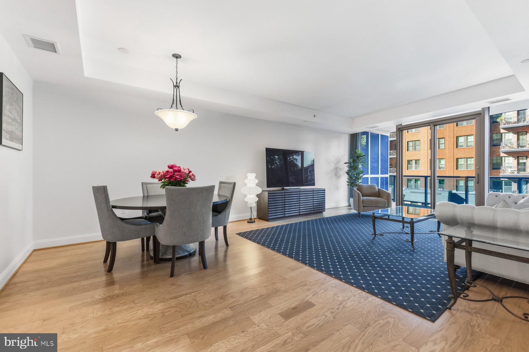 1881 North Nash Street, Unit 408 Arlington, VA 22209 - Photo 4 of 44 a view of a dining room with furniture wooden floor and a chandelier