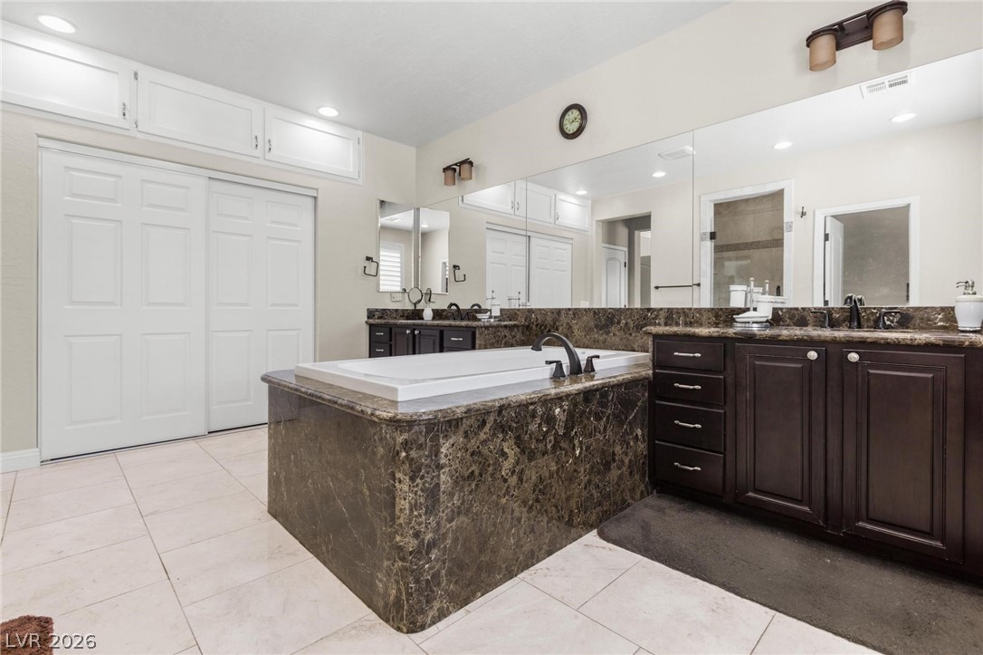 8431 Durango Ranch Court Las Vegas, NV 89113 - Photo 31 of 49 This spacious bathroom offers a relaxing soaking tub and elegant dark wood cabinetry.