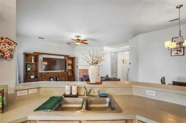 a kitchen with a refrigerator a sink and white cabinets