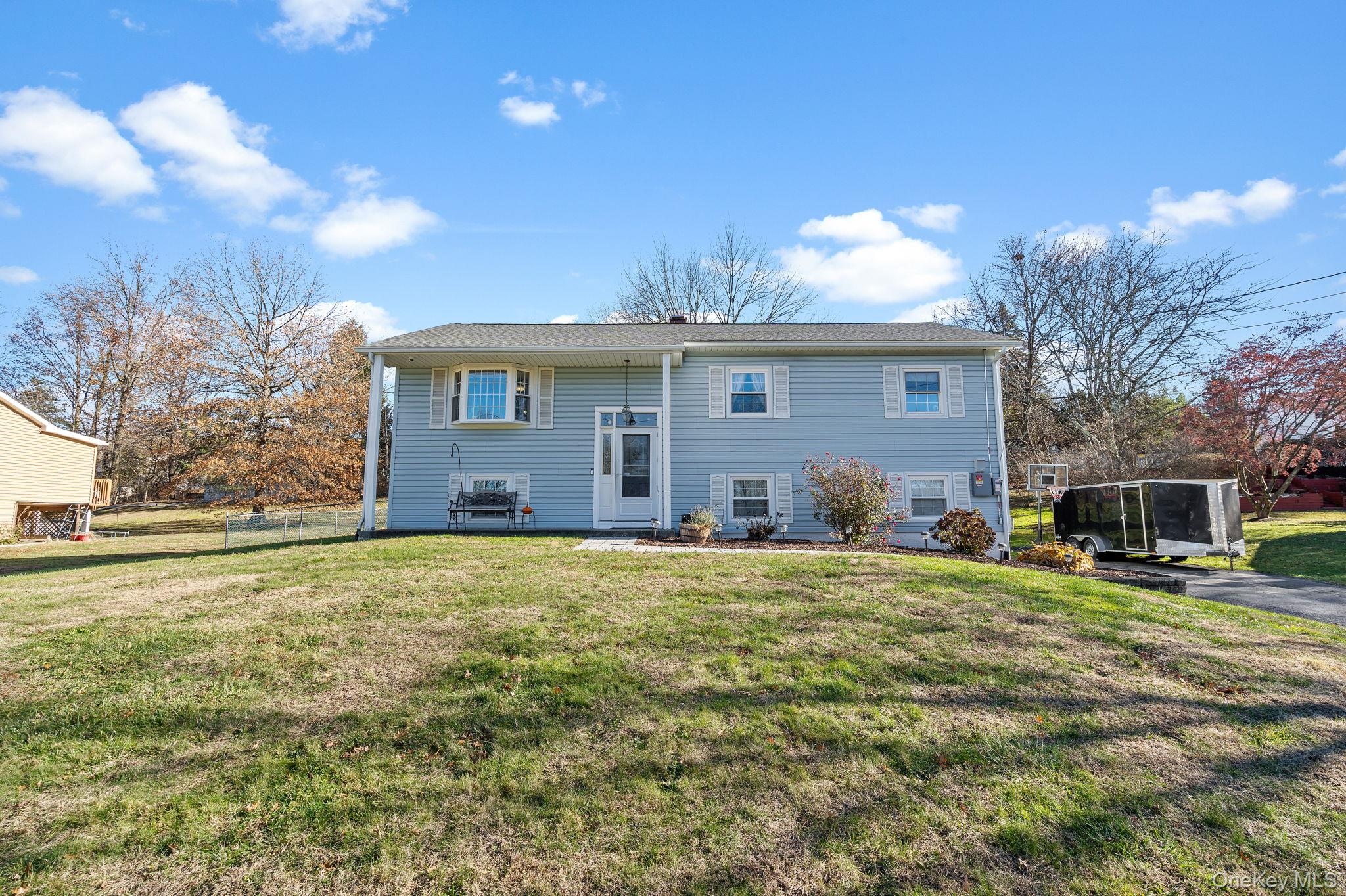 a front view of house with yard and trees in the background