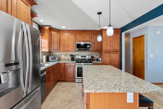 a kitchen with stainless steel appliances granite countertop a refrigerator a stove top oven a sink and dishwasher
