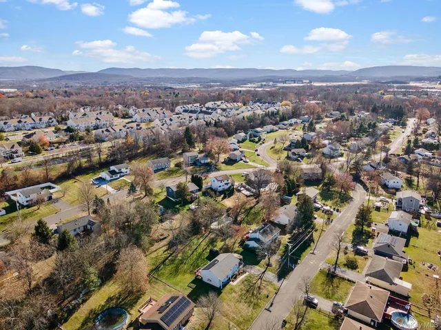an aerial view of house with yard and mountain view in back