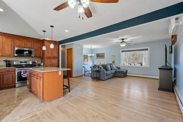 a kitchen with stainless steel appliances granite countertop a stove top oven a sink dishwasher a dining table and chairs with wooden floor