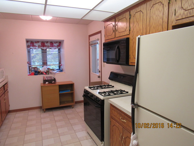 10640 Ridgeland Avenue, Unit 2A Chicago Ridge, IL 60415 - Photo 4 of 15 a kitchen with a stove and a microwave