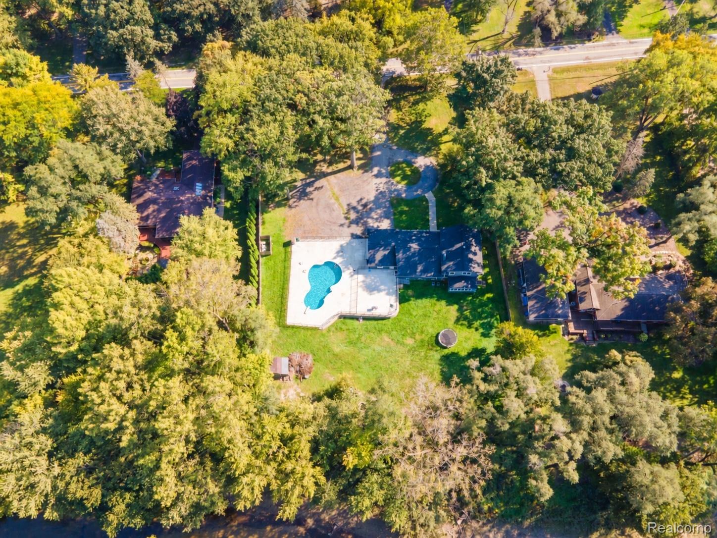 15879 Millar Road Clinton Township, MI 48036 - Photo 60 of 65 Property featuring a private swimming pool, expansive paved patio, and mature trees