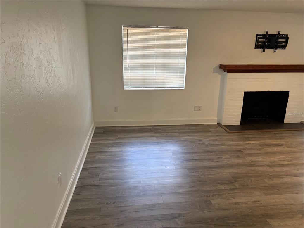 706 Northwest 20th Street Gainesville, FL 32603 - Photo 12 of 46 a view of an empty room with wooden floor and a fireplace