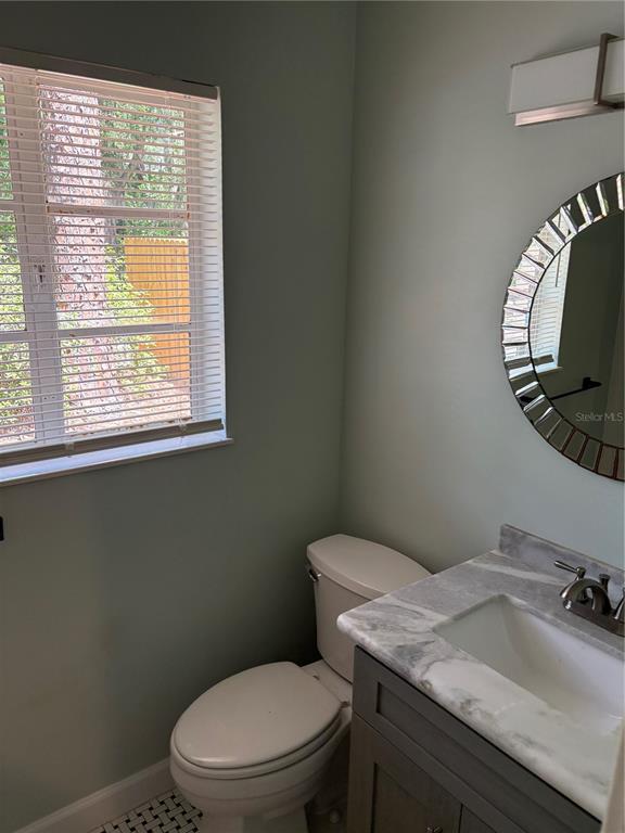 706 Northwest 20th Street Gainesville, FL 32603 - Photo 22 of 46 a bathroom with a toilet a sink and mirror