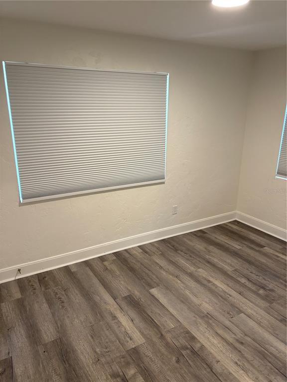 706 Northwest 20th Street Gainesville, FL 32603 - Photo 26 of 46 an empty room with wooden floor and windows