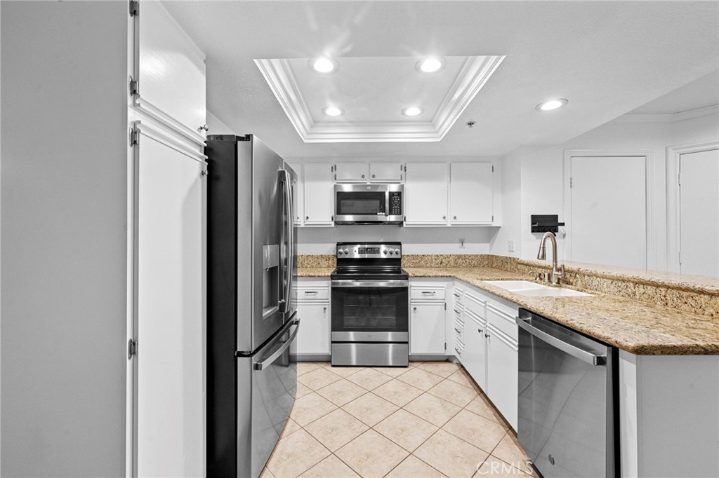 215 South Cross Creek Road, Unit L Orange, CA 92869 - Photo 9 of 50 a kitchen with stainless steel appliances granite countertop a refrigerator and a sink