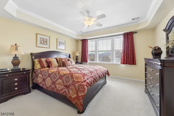a bedroom with a bed and a dresser with mirror
