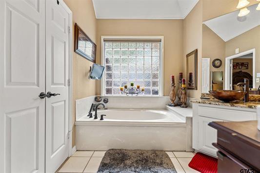 3621 Rock Creek Drive Tyler, TX 75707 - Photo 22 of 29 a bathroom with bathtub and a window