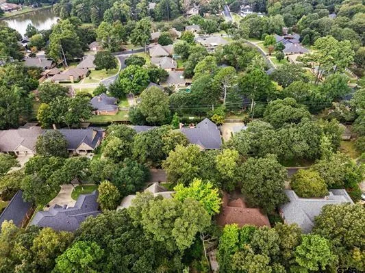 an aerial view of residential house with outdoor space and trees all around