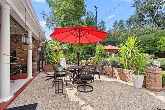a view of a backyard with table and chairs under an umbrella