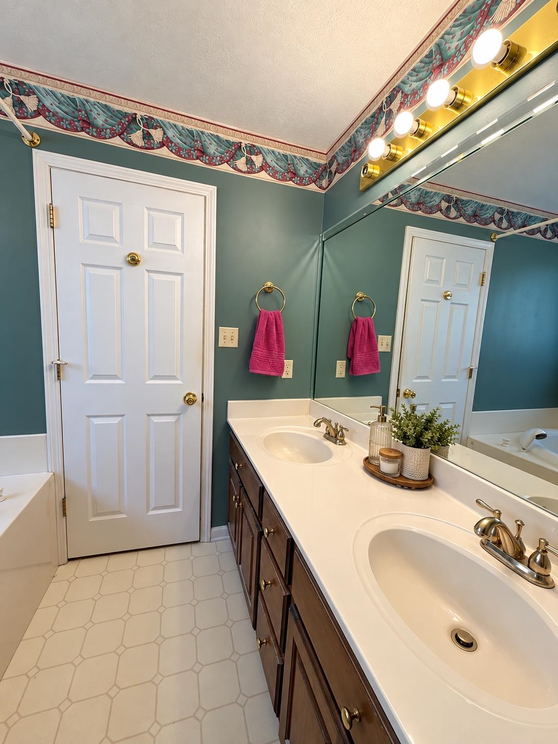 741 Dancer Road Selmer, TN 38375 - Photo 17 of 30 Double vanity with individual sinks, brass-finish fixtures, ample under-sink cabinetry, and a large wall-mounted mirror
