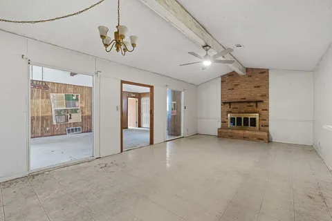 en empty room with windows and ceiling fan