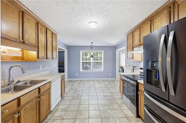 a kitchen with stainless steel appliances a sink stove and refrigerator