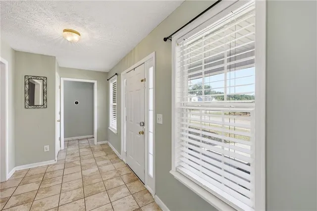 a view of a hallway with wooden floor and windows