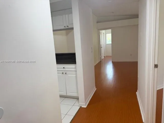 a view of a hallway with wooden floor and closet