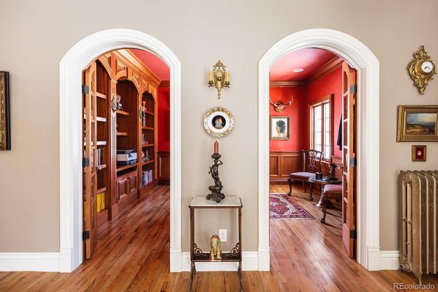 a view of front door with entryway and wooden floor