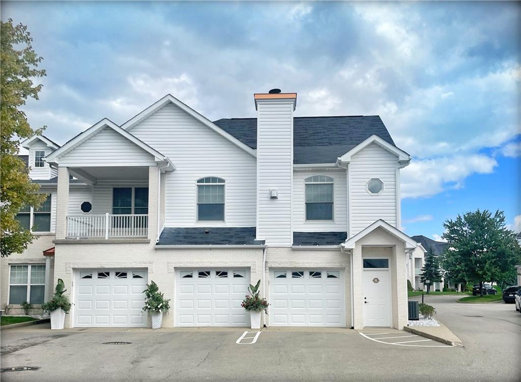 a view of a white house with a large windows and a yard
