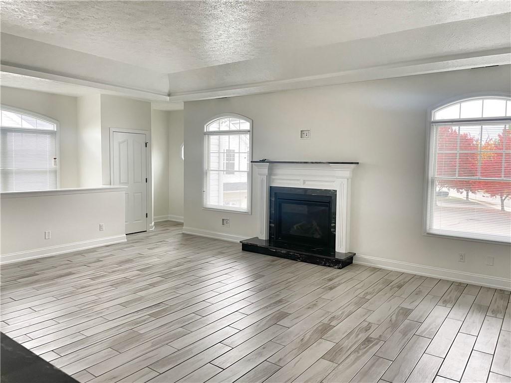 207 Adams Pointe Boulevard, Unit 6 Mars, PA 16046 - Photo 3 of 22 an empty room with wooden floor a fireplace and windows