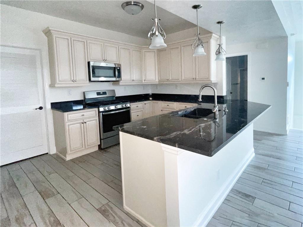207 Adams Pointe Boulevard, Unit 6 Mars, PA 16046 - Photo 6 of 22 a kitchen with stainless steel appliances granite countertop a sink a stove top oven a refrigerator with white cabinets and wooden floor