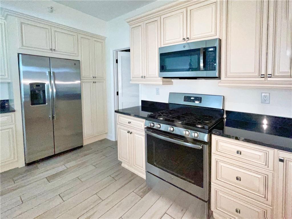 207 Adams Pointe Boulevard, Unit 6 Mars, PA 16046 - Photo 7 of 22 a kitchen with stainless steel appliances granite countertop a stove a microwave and a refrigerator