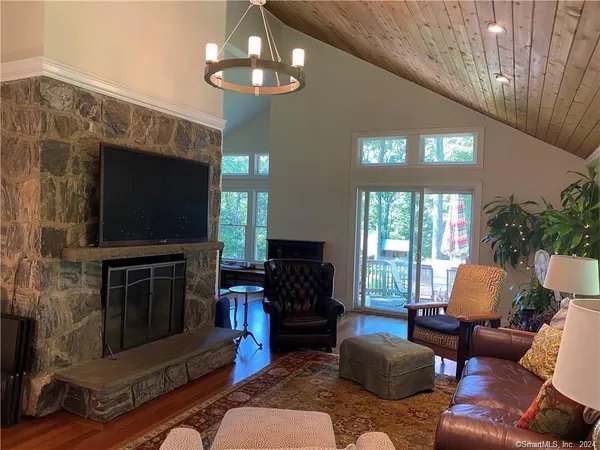 a living room with furniture wooden floor and a large window