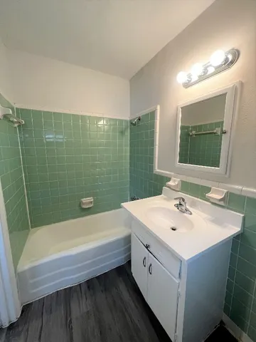 a bathroom with a tub a sink and mirror